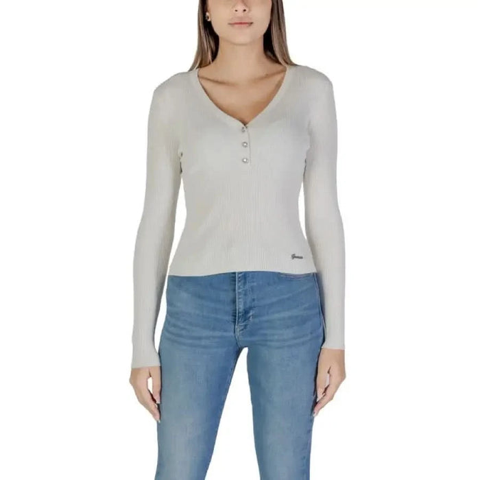 Woman in light-colored long-sleeved top and blue jeans wearing Guess Women’s Knitwear