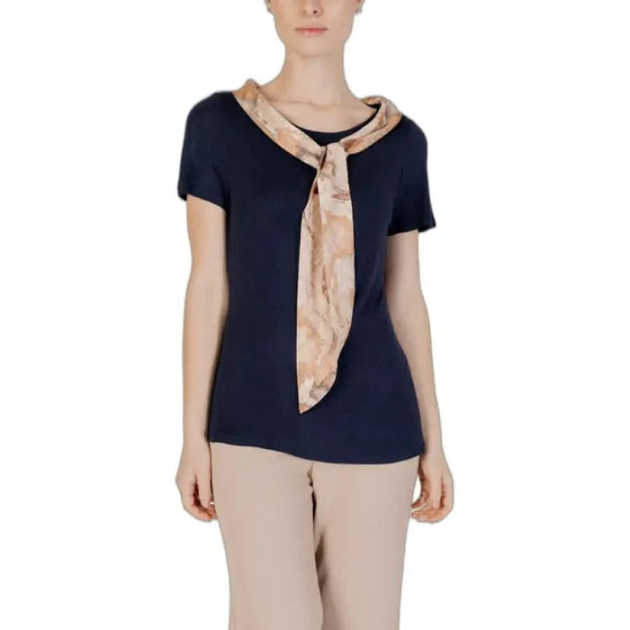 Alviero Martini Prima Classe woman in navy top with beige scarf