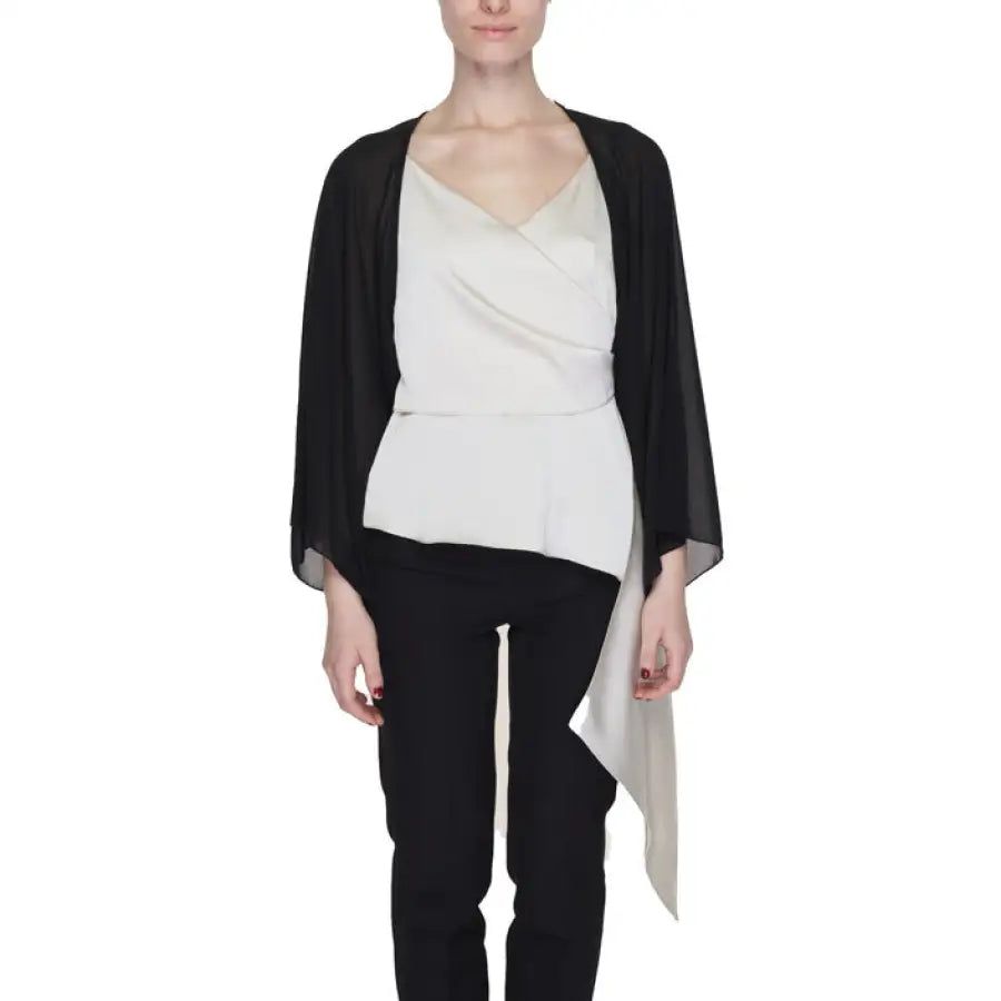 Woman in Sandro Ferrone black cardigan, white top, black pants - urban chic fashion look