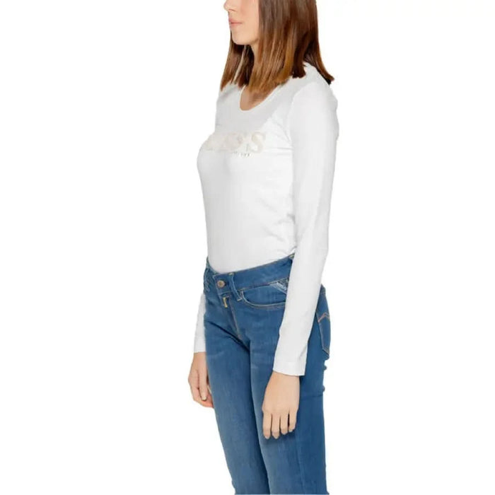 Woman in Guess White Long-Sleeved Top, Blue Jeans, Guess Women T-Shirt Collection