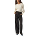 Stylish woman in Vero Moda white long-sleeved top and black wide-leg trousers