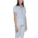 Woman in Alviero Martini Prima Classe white scrub top