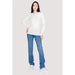 Woman in white sweater and blue jeans from Guess Women Knitwear collection