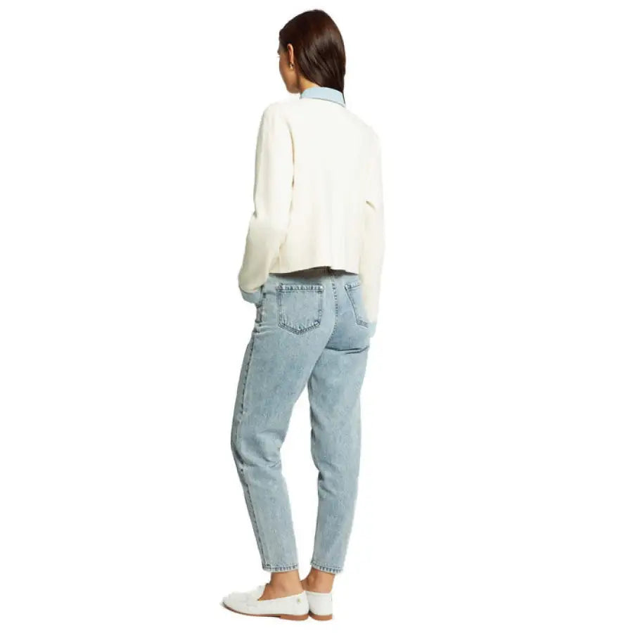 Rear view of woman in white sweater and blue jeans, wearing Morgan De Toi Women Cardigan