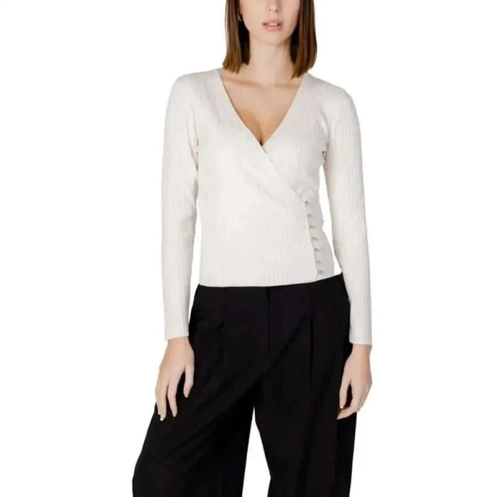 Woman in toi women knitwear featuring Morgan De Toi white sweater and black pants