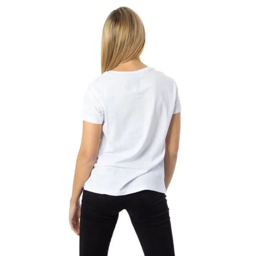 Back view of woman in white Armani Exchange t-shirt and black pants