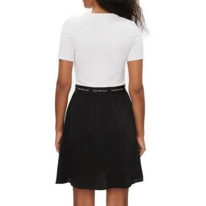 Back view of woman in Calvin Klein white t-shirt and black skirt from Calvin Klein Jeans