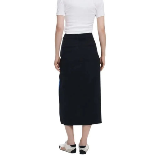 Woman in white t-shirt and navy Desigual skirt with zip and button closure