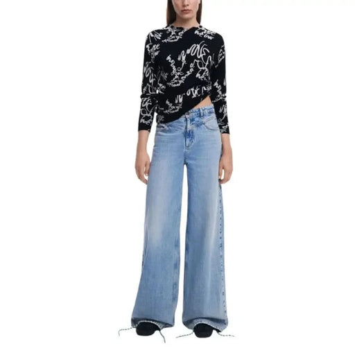 Woman’s black and white patterned sweater styled with wide-leg jeans from Desigual