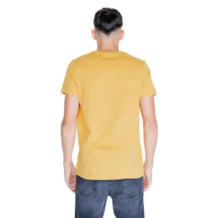 Person wearing Tommy Hilfiger Men T-Shirt in yellow, viewed from behind