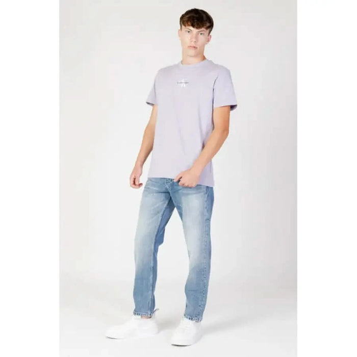 Young man in light gray t-shirt and blue jeans from Calvin Klein Jeans collection