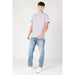 Young man in light gray t-shirt and blue jeans from Calvin Klein Jeans collection