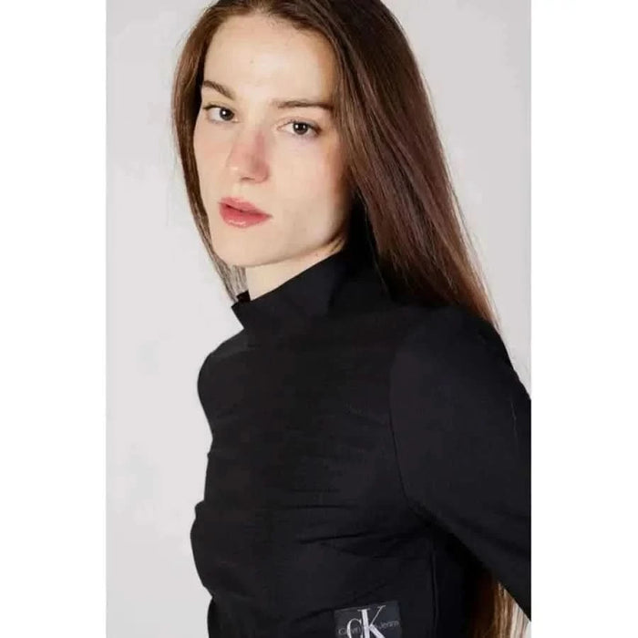 Young woman in black Calvin Klein turtleneck with long brown hair